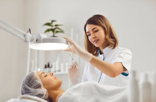 A female eye doctor is holding a syringe and about to administer an Anti-VEGF to the eye of a female patient with diabetic retinopathy.