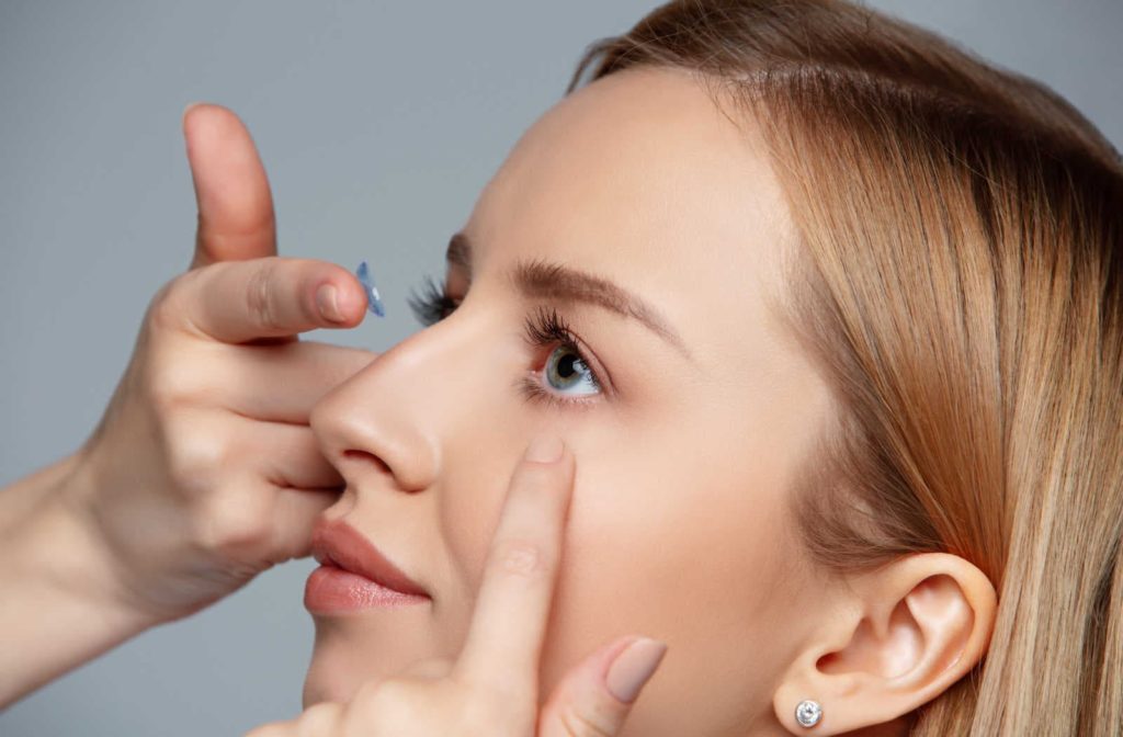 A woman putting in toric contact lenses as a solution to her astigmatism