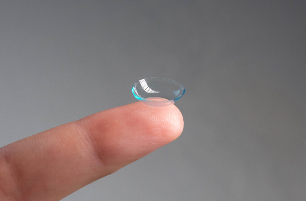 A close-up of a contact lens on the tip of a fringer.
