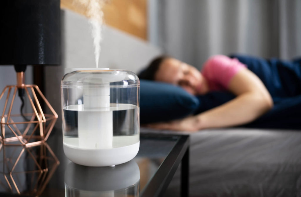 A woman is using a steam Air Humidifier while sleeping to relieve symptoms of dry eye syndrome.
