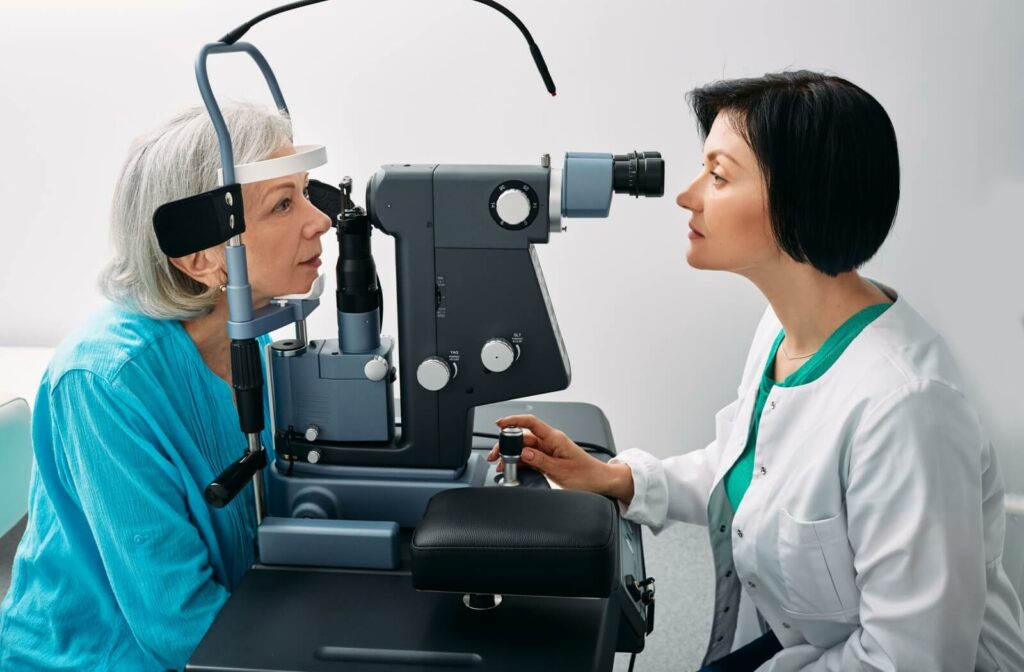 An optometrist performing a slit-lamp exam on a senior patient.