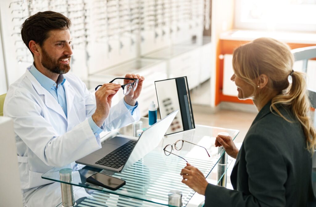 An optician adjusts their patient's new eyeglasses.