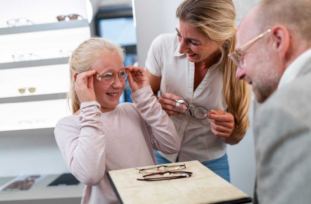 A young patient trying on a new pair of glasses at their optometrist's office after getting a new prescription during an eye exam.